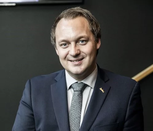 Frank Ove Wennevik – General Manager, Radisson Blu Hotel Bergen in a suit, leaning towards a stairway